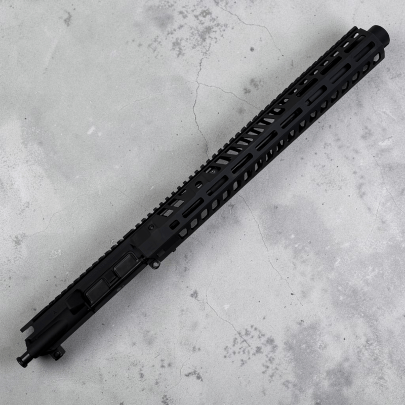 Long black rifle handguard with vented slots lying diagonally on a gray concrete surface. - 10.5″ .300 Blackout AR-15 Upper – Suppressor-Ready | 15″ M-LOK Handguard & Mock Suppressor - Mid State Firearms , Mid State Firearms