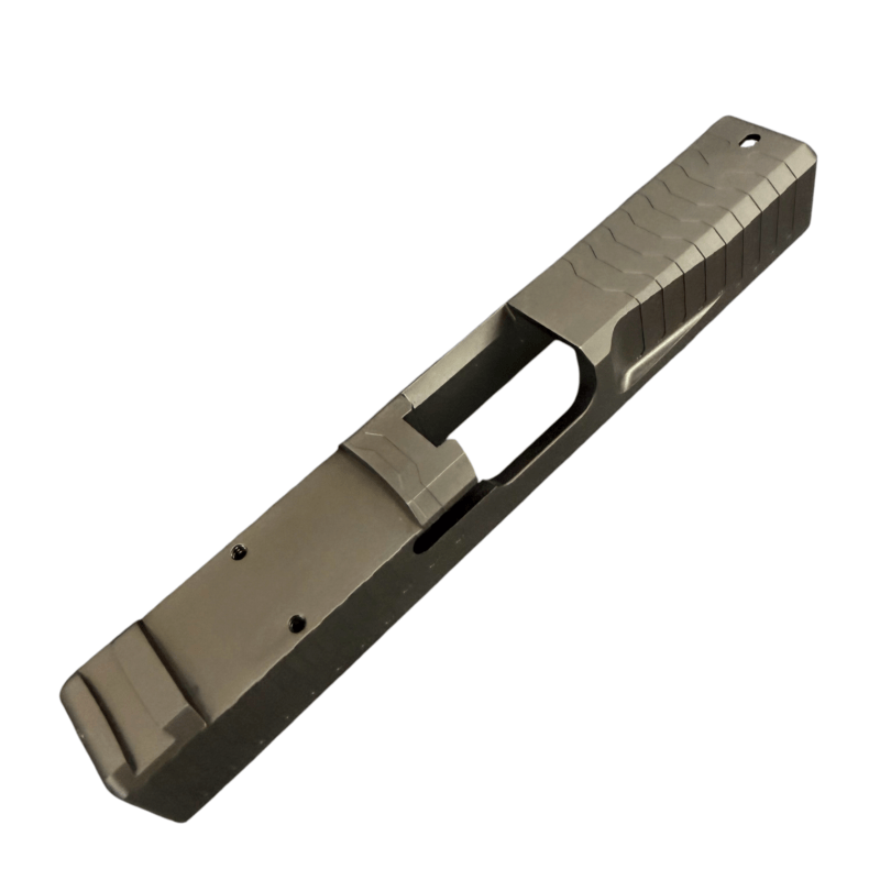 Close-up of a metallic pistol slide with serrated top and ejection port, viewed diagonally across a white background. - Glock 19 Gen 3 RMR Slide | Black DLC - Matrix Drip Serrated , Mid State Firearms